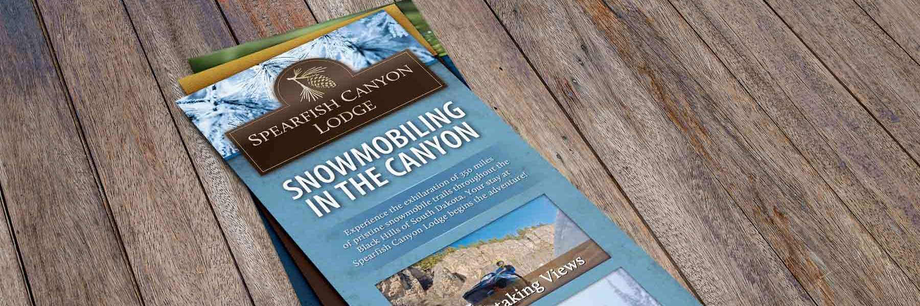 Spearfish Canyon Lodge rack cards on a wooden table